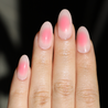 Light skinned hand with light and dark pink aura nails