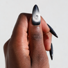 Dark skinned thumb with Black Cateye Gem Nails