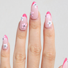 Light skinned hand with Pink Gem Floral French Tips