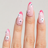 Light skinned hand with Pink Gem Floral French Tips