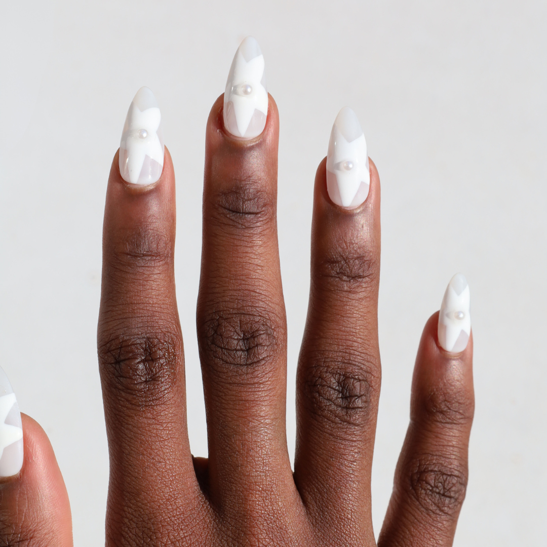 Dark skinned hand with Winter White Star Pearl Nails
