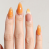 Light skinned hand with Orange Chrome Moderne Nails
