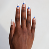 Dark skinned hand with Blue Star French Tips