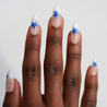 Dark skinned hand with Blue Star French Tips