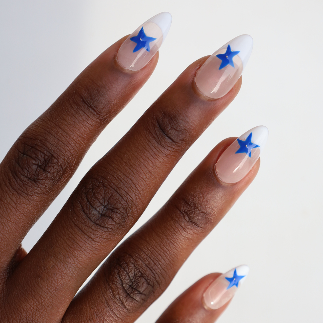 Angled photo of dark skinned hand with Blue Star French Tips