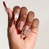 Dark skinned hand with Cherry 3D Bow Coffin Nails