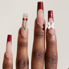 Dark skinned hand with Cherry 3D Bow Coffin Nails