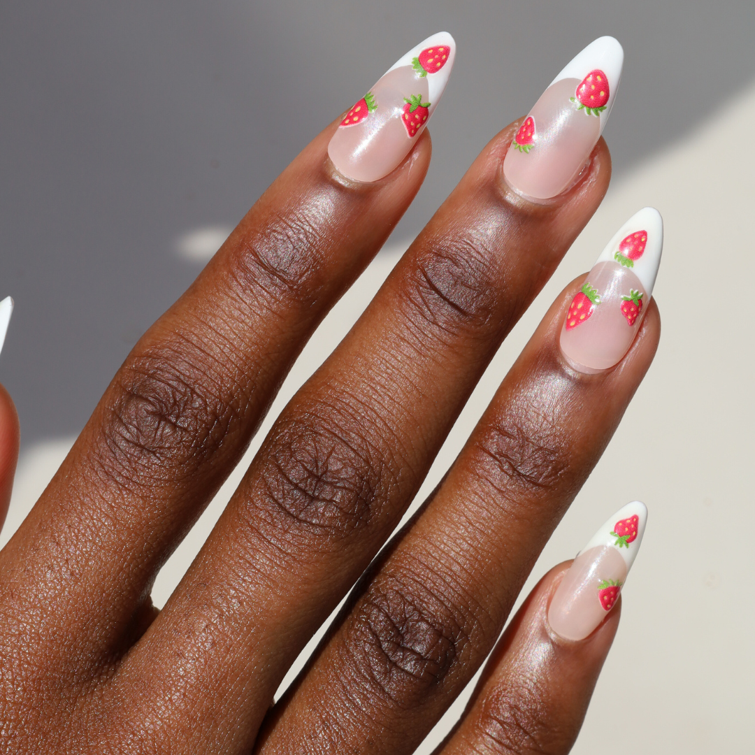 Angled photo of dark skinned hand with Strawberry French Tip Nails