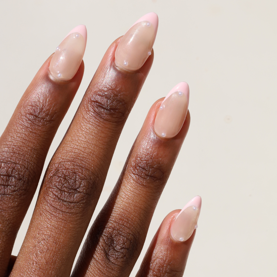 Angled photo of dark skinned hand with Pearl Nude French Tip Nails