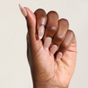 Dark skinned hand with Pearl Nude French Tip Nails