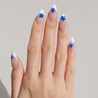 Light skinned hand with Blue Star French Tips