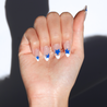Light skinned hand with Blue Star French Tips