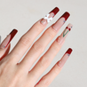 Angled photo of light skinned hand with Cherry 3D Bow Coffin Nails