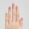Light skinned hand with Pearl Nude French Tip Nails