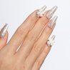 Angled photo of light skinned hand with White Chrome 3D Bow Pearl Nails