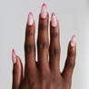 Dark skinned hand with Pink Gem Floral French Tips