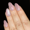 Angled photo of light skinned hand with pink cat-eye nails