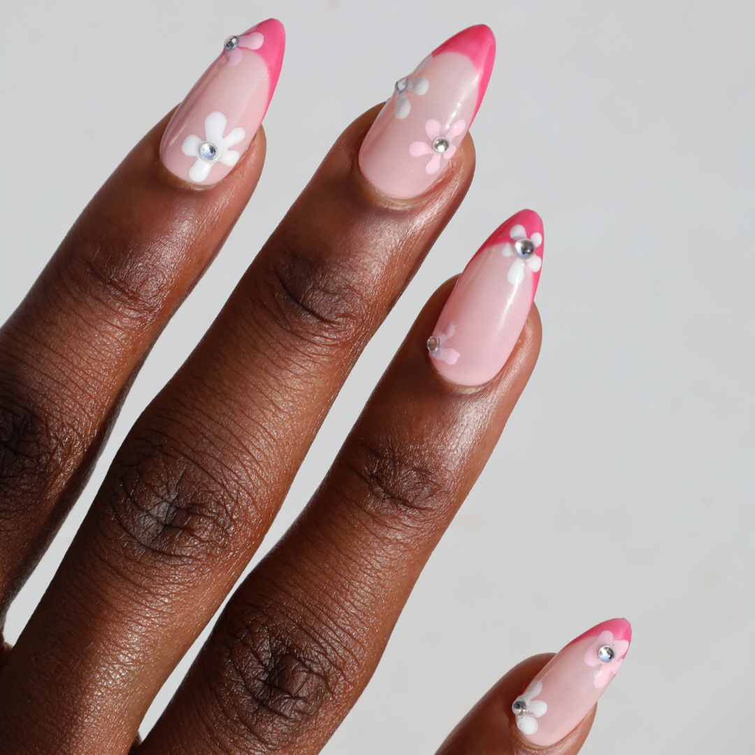 Angled photo of dark skinned hand with Pink Gem Floral French Tips