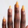 Dark skinned hand with Orange Chrome Moderne Nails