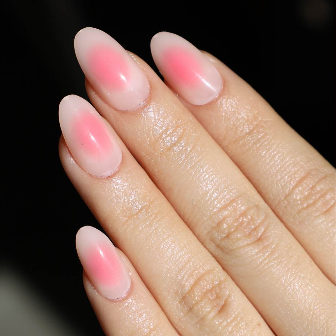 Angeled light skinned hand with light and dark pink aura nails