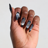 Dark skinned hand with Black Cateye Gem Nails
