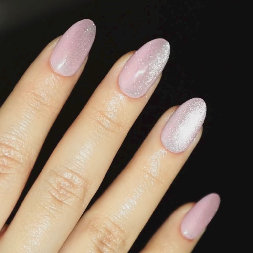 Video of light skinned hand with pink cat-eye nails