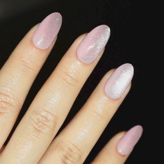 Video of light skinned hand with pink cat-eye nails