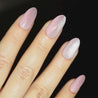 Video of light skinned hand with pink cat-eye nails