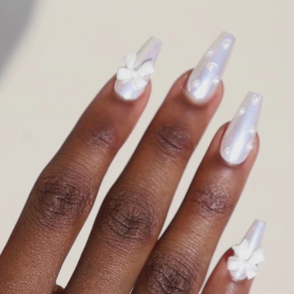 Video of dark skinned hand with White Chrome 3D Bow Pearl Nails